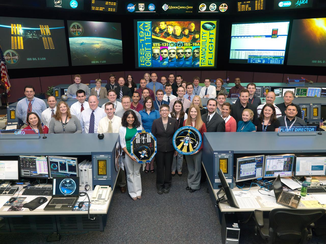 JSC2010-E-052979 (14 April 2010) --- The members of the STS-131/19A ISS Orbit 1 flight control team pose for a group portrait in the space station flight control room in the Mission Control Center at NASA's Johnson Space Center. Flight director Courtenay McMillan (center) stands on the front row.