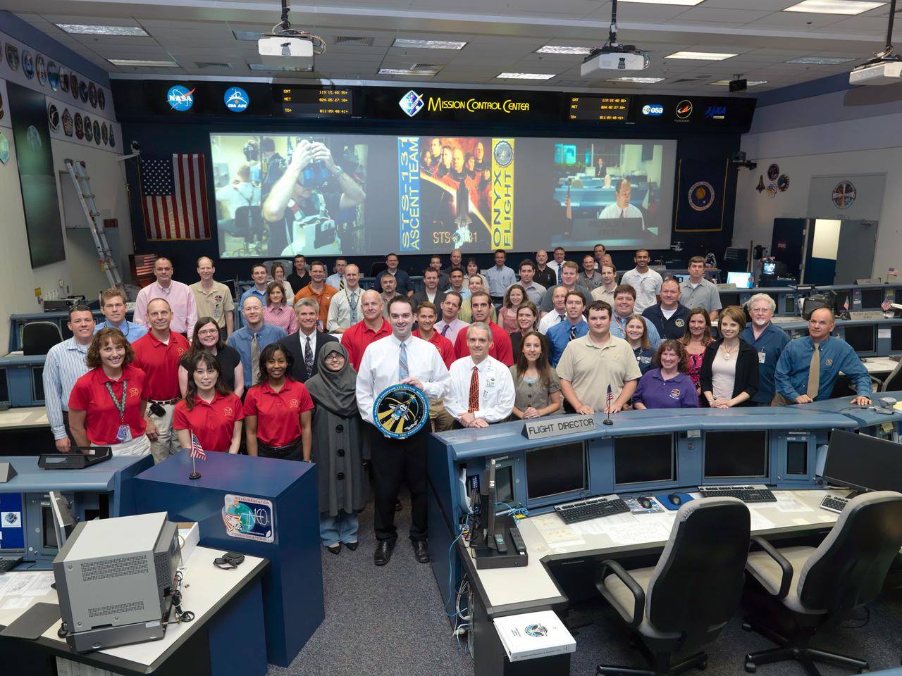 JSC2010-E-060725 (29 April 2010) --- The members of the STS-131 Ascent flight control team and crew members pose for a group portrait in the space shuttle flight control room in the Mission Control Center at NASA's Johnson Space Center. Flight director Bryan Lunney and NASA astronaut Alan Poindexter, commander, (left center) stand on the second row. Additional crew members pictured are NASA astronauts James P. Dutton Jr., pilot; Clayton Anderson, Dorothy Metcalf-Lindenburger, Stephanie Wilson, Rick Mastracchio and Japan Aerospace Exploration Agency (JAXA) astronaut Naoko Yamazaki, all mission specialists.