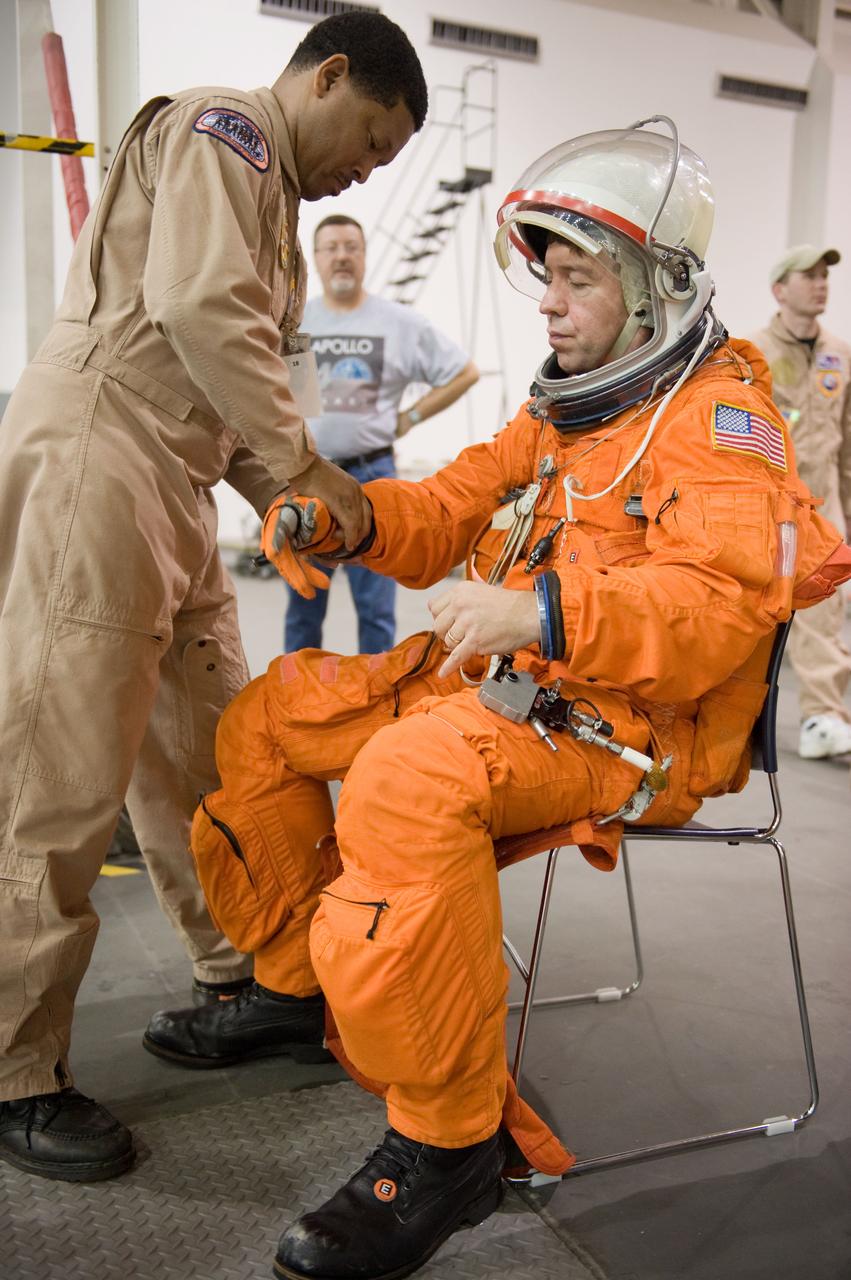 JSC2010-E-075021 (7 May 2010) --- NASA astronaut Michael Barratt, STS-133 mission specialist, dons a training version of his shuttle launch and entry suit in preparation for a training session in the Neutral Buoyancy Laboratory (NBL) near NASA's Johnson Space Center. Suit technician George Brittingham assisted Barratt.
