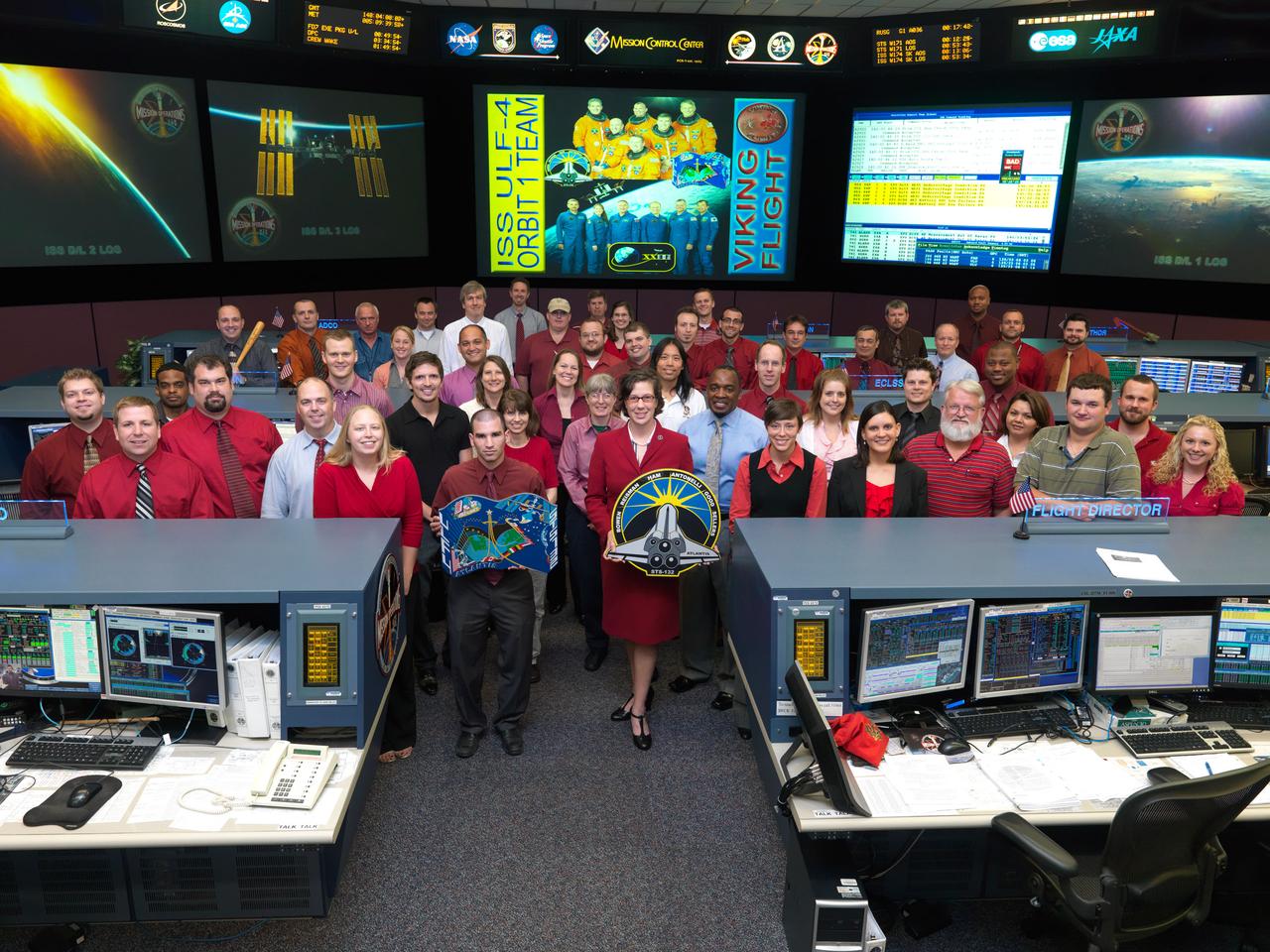 JSC2010-E-086277 (19 May 2010) --- The members of the STS-132/ULF-4 ISS Orbit 1 flight control team pose for a group portrait in the space station flight control room in the Mission Control Center at NASA's Johnson Space Center. Flight director Holly Ridings holds the STS-132 mission logo.