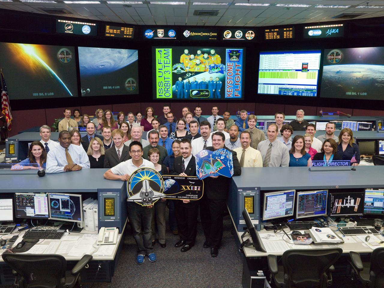 JSC2010-E-086504 (20 May 2010) --- The members of the STS-132/ULF-4 ISS Orbit 3 flight control team pose for a group portrait in the space station flight control room in the Mission Control Center at NASA's Johnson Space Center. Flight director Scott Stover holds the Expedition 23 mission logo.