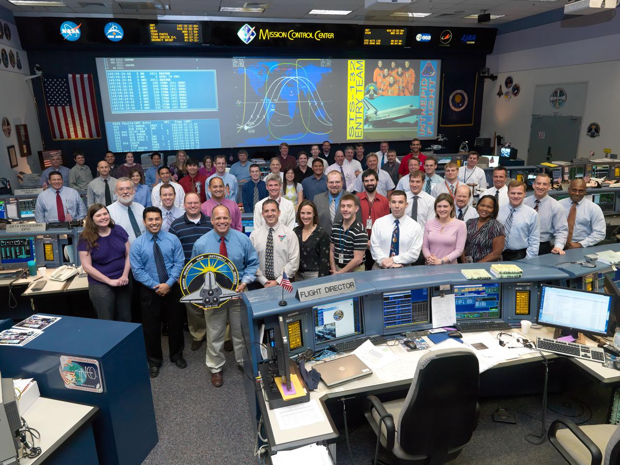 JSC2010-E-087358 (25 May 2010) --- The members of the STS-132 Entry flight control team pose for a group portrait in the space shuttle flight control room in the Mission Control Center at NASA's Johnson Space Center. Flight director Tony Ceccacci holds the STS-132 mission logo. Photo credit: NASA or National Aeronautics and Space Administration