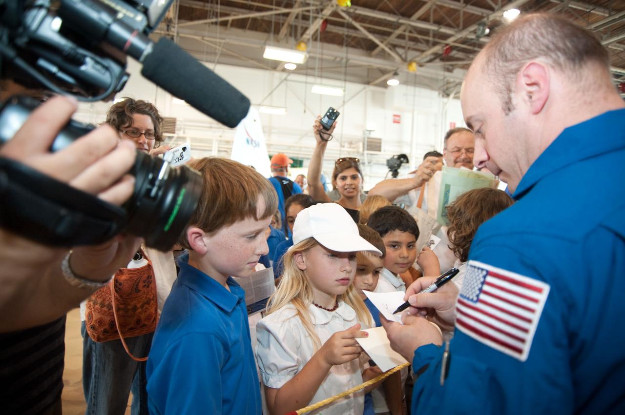 JSC2010-E-089700 (27 May 2010) --- At Ellington Field's Hangar 276, NASA astronaut Garrett Reisman, STS-132 mission specialist, signs autographs for some young visitors at the crew return ceremony for space shuttle Atlantis' final scheduled mission. Photo credit: NASA or National Aeronautics and Space Administration