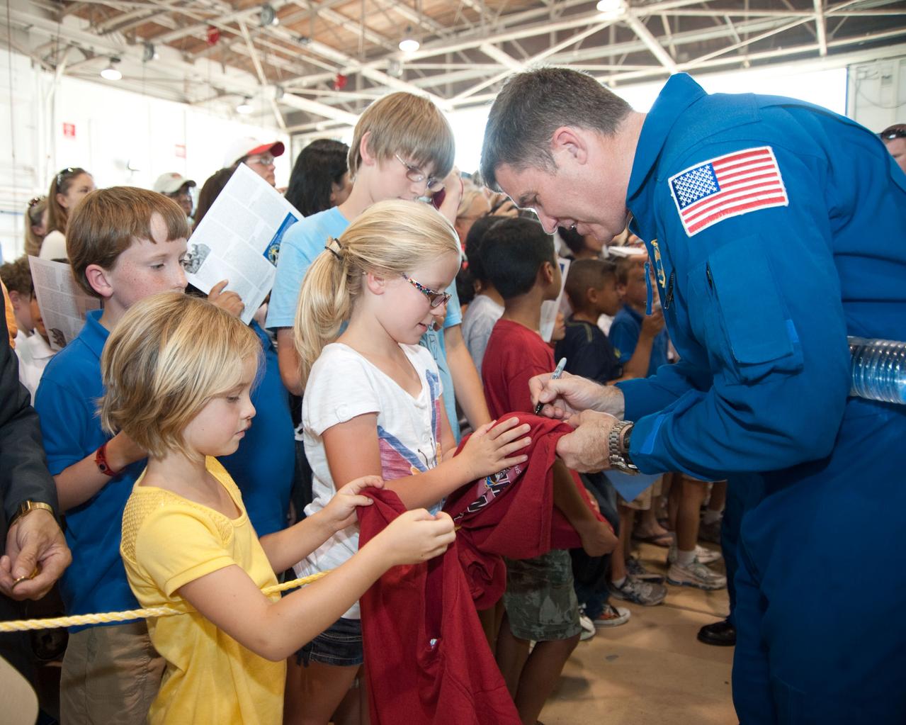 JSC2010-E-089705 (27 May 2010) ---  At Ellington Field's Hangar 276, NASA astronaut Steve Bowen (right foreground), STS-132 mission specialist, signs autographs for some young visitors at the crew return ceremony for space shuttle Atlantis' final scheduled mission. Photo credit: NASA or National Aeronautics and Space Administration