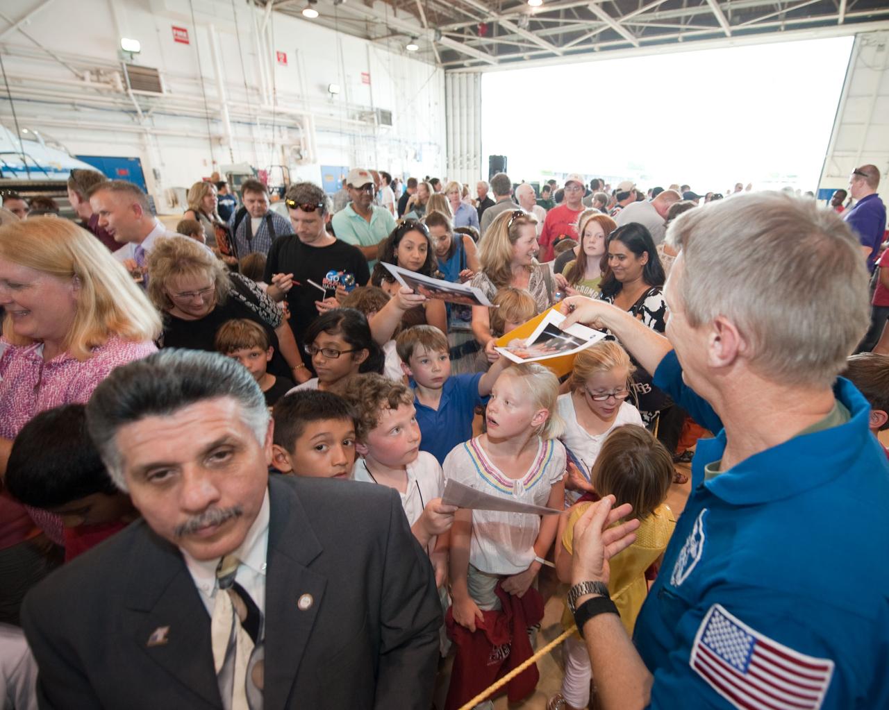 JSC2010-E-089710 (27 May 2010) --- At Ellington Field's Hangar 276, NASA astronaut Piers Sellers (right foreground), STS-132 mission specialist, signs autographs for a number of well-wishers at the crew return ceremony for space shuttle Atlantis' final scheduled mission. Photo credit: NASA or National Aeronautics and Space Administration