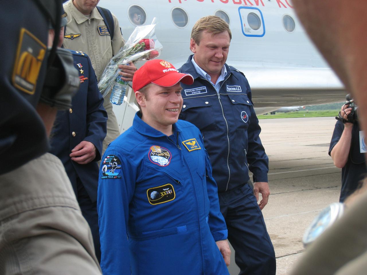 At Chkalovsky Airbase outside Star City, Russia, Expedition 23 Commander Oleg Kotov is greeted at the foot of the stairs of the plane that brought him home from Kazakhstan June 2, 2010 after he and Flight Engineers T.J. Creamer and Soichi Noguchi landed in the Soyuz TMA-17 spacecraft earlier in the day to wrap up 163 days in space. Kotov is assisted by Alexei Krasnov (R), the head of Piloted Programs for the Russian Federal Space Agency.  Credit:  NASA/Stephanie Stoll 