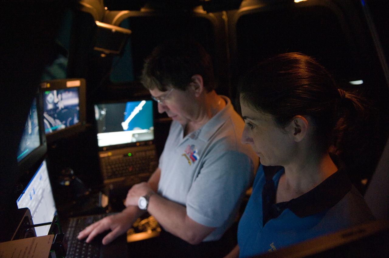 JSC2010-E-090695 (8 June 2010) --- NASA astronauts Nicole Stott and Michael Barratt, both STS-133 mission specialists, participate in an exercise in the systems engineering simulator in the Avionics Systems Laboratory at NASA's Johnson Space Center. The facility includes moving scenes of full-sized International Space Station components over a simulated Earth.