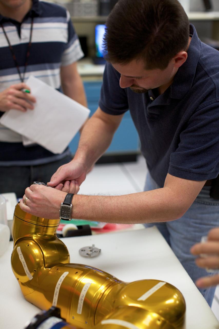 JSC2010-E-090923 (15 March 2010)  --- One of Robonaut 2?s arms is disassembled to prepare the robot for electronics upgrades. Because R2 was designed as a prototype, some changes were necessary to ready it for life on the International Space Station. R2 is scheduled to launch into space aboard Discovery on the STS-133 mission. Photo credit: NASA or National Aeronautics and Space Administration