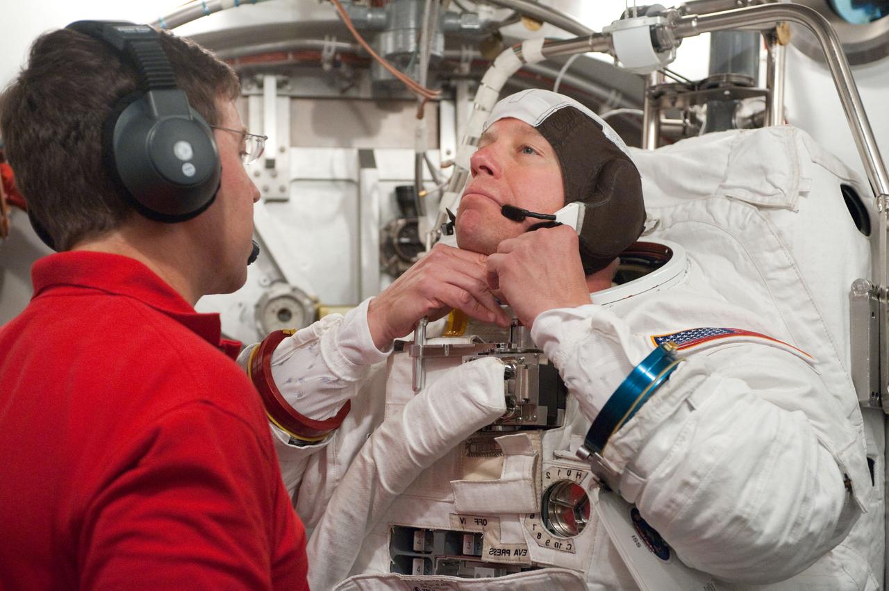 JSC2010-E-098594 (22 June 2010) --- NASA astronaut Tim Kopra, STS-133 mission specialist, participates in an Extravehicular Mobility Unit (EMU) spacesuit fit check in the Space Station Airlock Test Article (SSATA) in the Crew Systems Laboratory at NASA's Johnson Space Center. Astronaut Michael Barratt, mission specialist, assisted Kopra.
