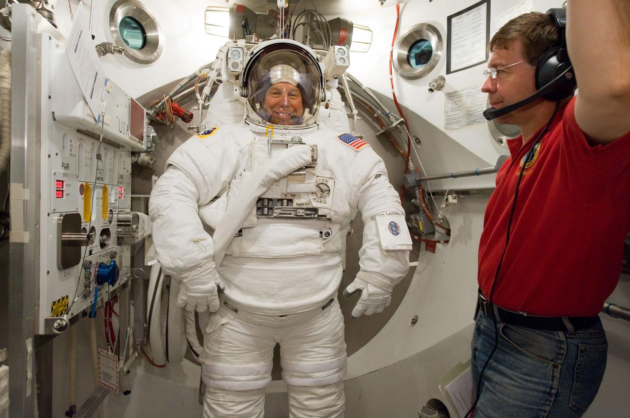 JSC2010-E-098608 (22 June 2010) --- NASA astronaut Tim Kopra, STS-133 mission specialist, participates in an Extravehicular Mobility Unit (EMU) spacesuit fit check in the Space Station Airlock Test Article (SSATA) in the Crew Systems Laboratory at NASA's Johnson Space Center. Astronaut Michael Barratt, mission specialist, assisted Kopra.