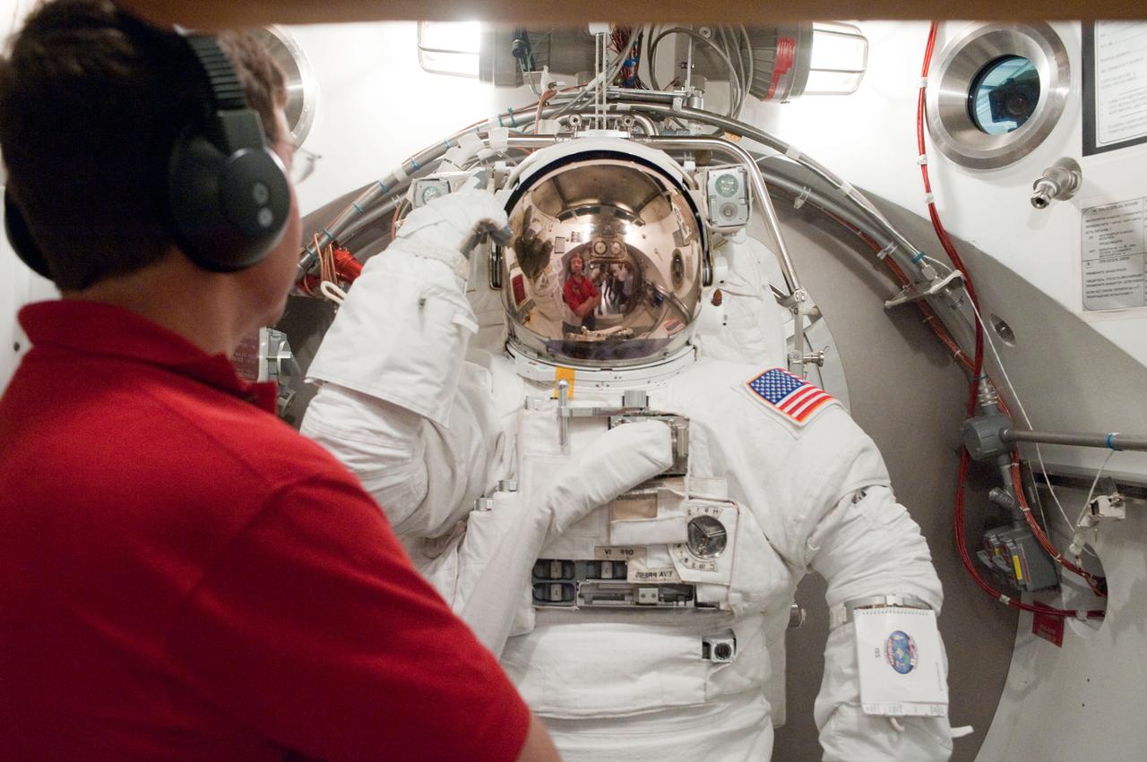 JSC2010-E-098614 (22 June 2010) --- NASA astronaut Tim Kopra, STS-133 mission specialist, participates in an Extravehicular Mobility Unit (EMU) spacesuit fit check in the Space Station Airlock Test Article (SSATA) in the Crew Systems Laboratory at NASA's Johnson Space Center. Astronaut Michael Barratt, mission specialist, assisted Kopra.