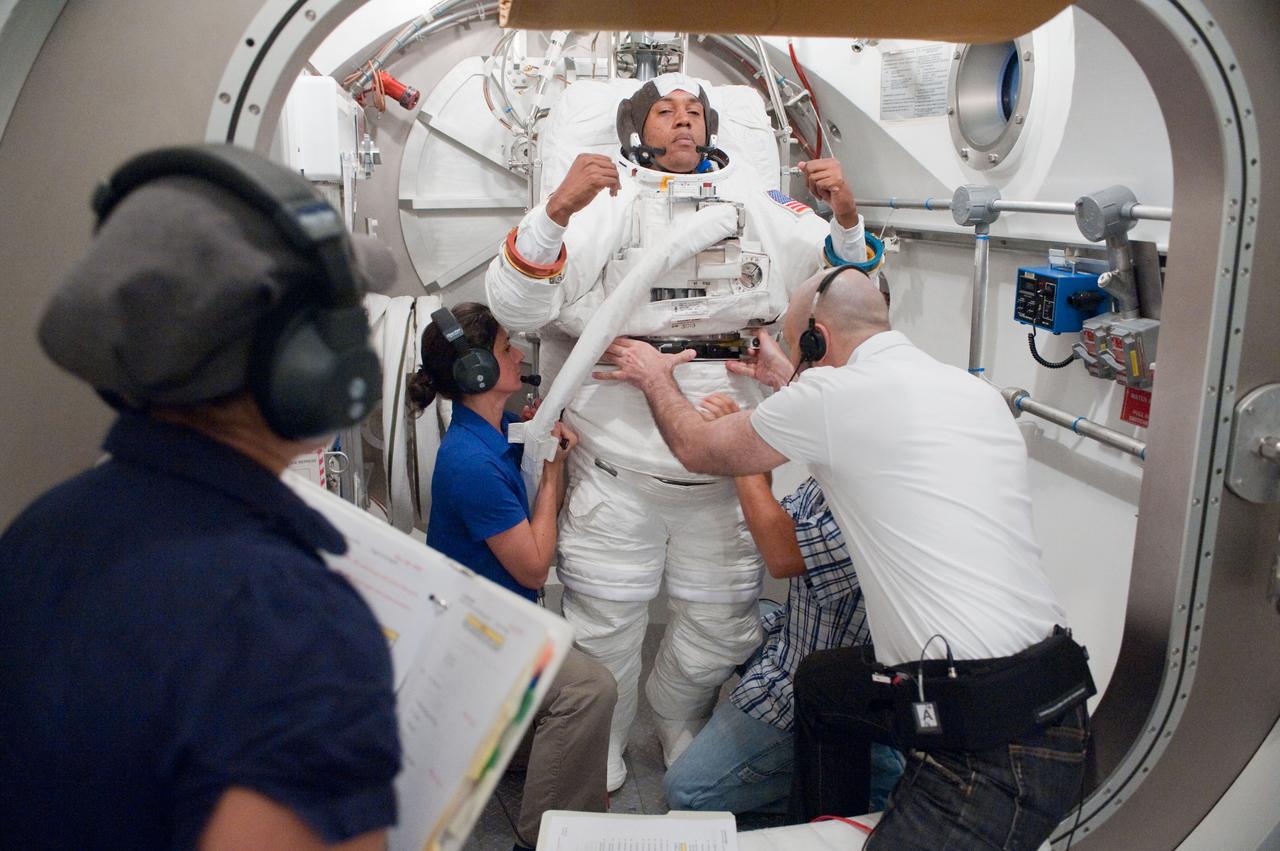 JSC2010-E-101114 (24 June 2010) --- NASA astronaut Alvin Drew, STS-133 mission specialist, participates in an Extravehicular Mobility Unit (EMU) spacesuit fit check in the Space Station Airlock Test Article (SSATA) in the Crew Systems Laboratory at NASA's Johnson Space Center. Astronaut Nicole Stott, mission specialist, and suit technicians assisted Drew. Photo credit: NASA or National Aeronautics and Space Administration