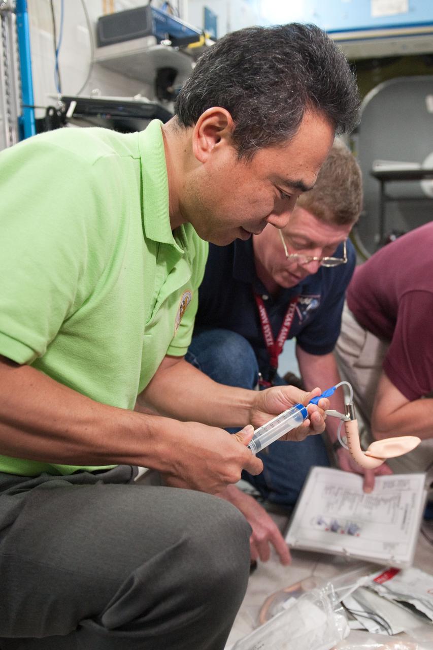 PHOTO DATE:  07-13-10 LOCATION: Bldg 9NW, US Lab Mockup SUBJECT:  Expedition 28 crew membersMike Fossum, Satoshi Furukawa, Sergei Volkov  during ACLS MEG I training. PHOTOGRAPHER:  James Blair