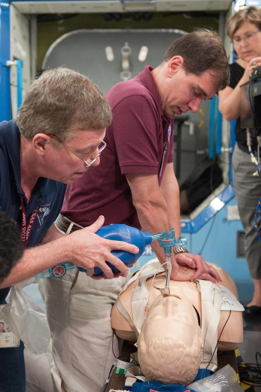 PHOTO DATE:  07-13-10 LOCATION: Bldg 9NW, US Lab Mockup SUBJECT:  Expedition 28 crew membersMike Fossum, Satoshi Furukawa, Sergei Volkov  during ACLS MEG I training. PHOTOGRAPHER:  James Blair