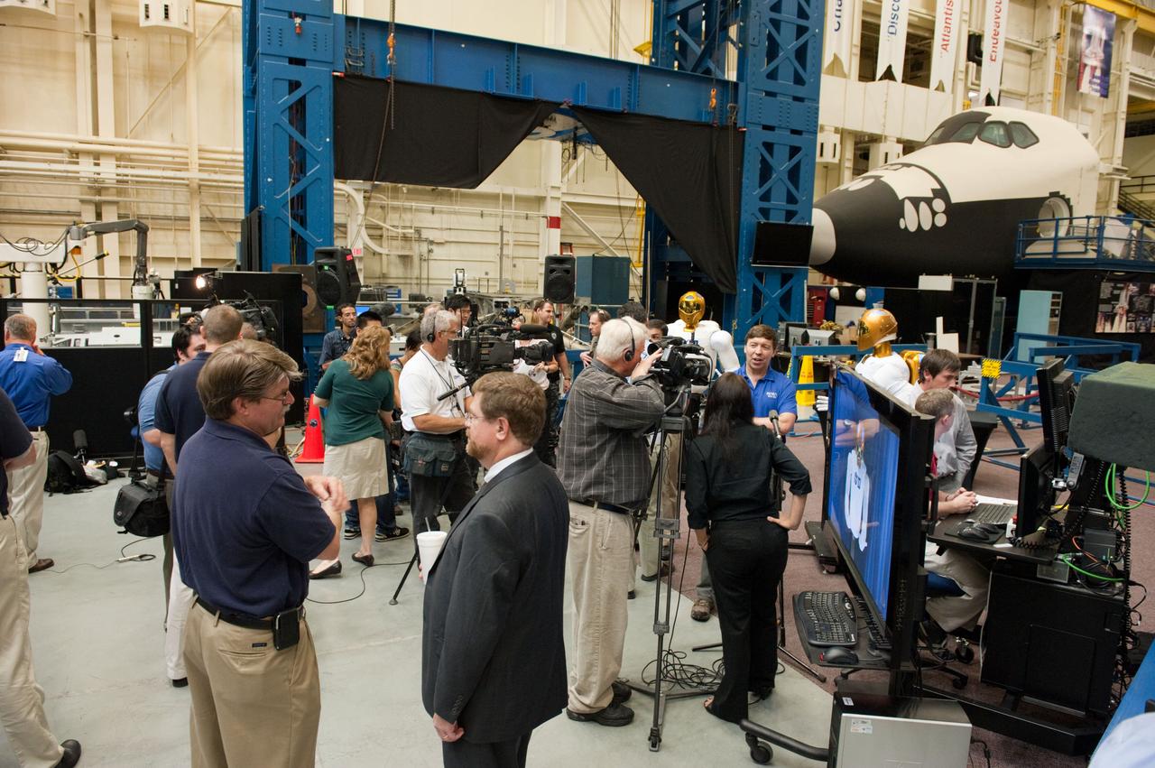 JSC2010-E-112717 (4 Aug. 2010) --- NASA personnel and members of the media are pictured during Robonaut 2 (R2) media day in the Space Vehicle Mock-up Facility at NASA's Johnson Space Center. R2, who will hitch a ride with the STS-133 crew members, is the first humanoid robot to travel to space and the first U.S.-built robot to visit the International Space Station. R2 will stay on the space station indefinitely to allow engineers on the ground to learn more about how humanoid robots fare in microgravity. Photo credit: NASA or National Aeronautics and Space Administration