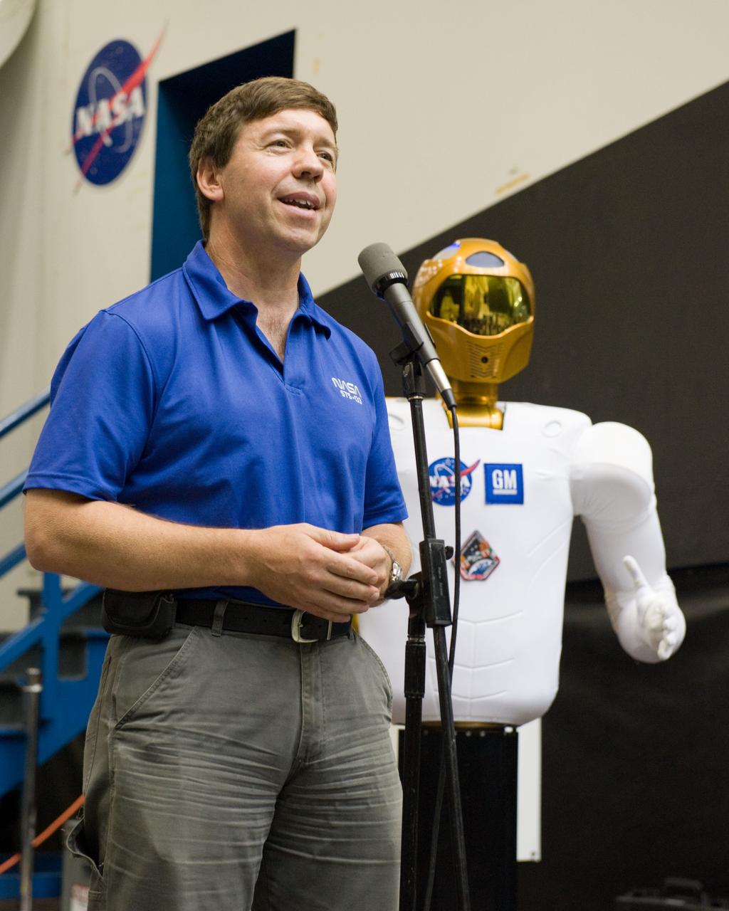 JSC2010-E-112826 (4 Aug. 2010) --- NASA astronaut Michael Barratt, STS-133 mission specialist, speaks to members of the media and NASA personnel during Robonaut 2 (R2) media day in the Space Vehicle Mock-up Facility at NASA's Johnson Space Center. R2, who will hitch a ride with the STS-133 crew members, is the first humanoid robot to travel to space and the first U.S.-built robot to visit the International Space Station. R2 will stay on the space station indefinitely to allow engineers on the ground to learn more about how humanoid robots fare in microgravity. Photo credit: NASA or National Aeronautics and Space Administration
