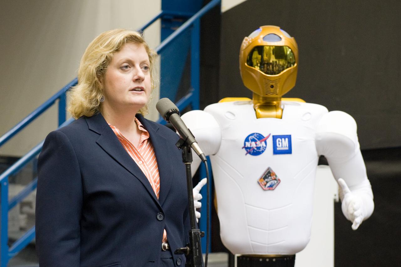 JSC2010-E-112828 (4 Aug. 2010) --- Julie Robinson, physical scientist, speaks to members of the media and NASA personnel during Robonaut 2 (R2) media day in the Space Vehicle Mock-up Facility at NASA's Johnson Space Center. R2, who will hitch a ride with the STS-133 crew members, is the first humanoid robot to travel to space and the first U.S.-built robot to visit the International Space Station. R2 will stay on the space station indefinitely to allow engineers on the ground to learn more about how humanoid robots fare in microgravity. Photo credit: NASA or National Aeronautics and Space Administration