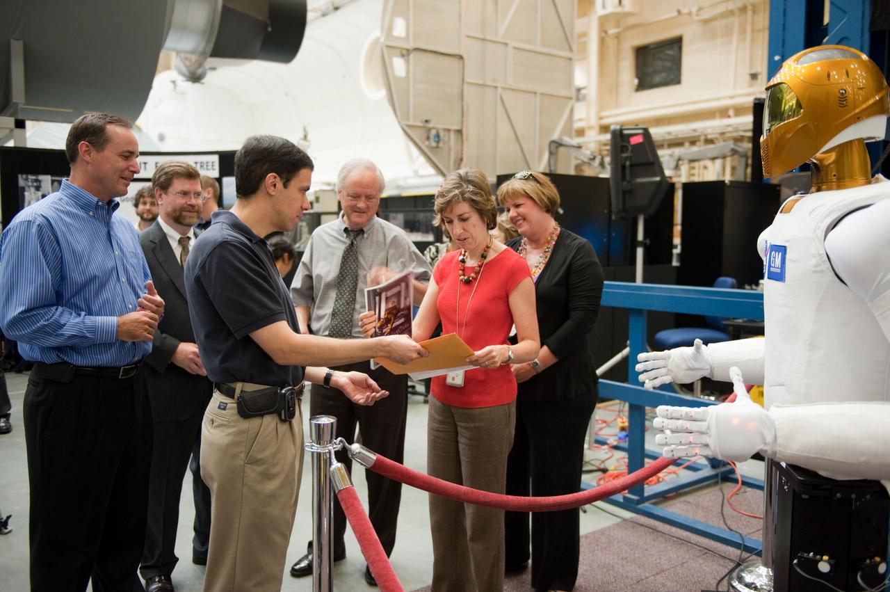 JSC2010-E-113079 (4 Aug. 2010) --- NASA's Johnson Space Center (JSC) deputy director Ellen Ochoa (right foreground), Milt Heflin (center background), associate director; and Ron Diftler, Robonaut project manager, are pictured during Robonaut 2 (R2) media day in the Space Vehicle Mock-up Facility at JSC. R2, who will hitch a ride with the STS-133 crew members, is the first humanoid robot to travel to space and the first U.S.-built robot to visit the International Space Station. R2 will stay on the space station indefinitely to allow engineers on the ground to learn more about how humanoid robots fare in microgravity. Photo credit: NASA