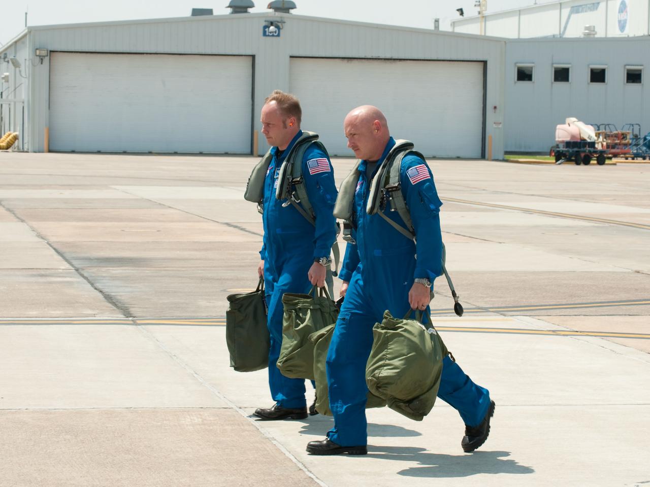 JSC2010-E-119539 (25 Aug. 2010) --- NASA astronauts Mark Kelly (foreground), STS-134 commander; and Michael Fincke, mission specialist, walk to the nearby flight line of NASA T-38 trainer jets at Ellington Field near NASA's Johnson Space Center prior to a familiarization flight. Photo credit: NASA or National Aeronautics and Space Administration