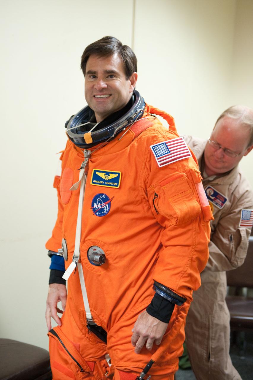 JSC2010-E-124263 (8 Sept. 2010) --- NASA astronaut Greg Chamitoff, STS-134 mission specialist, dons a training version of his shuttle launch and entry suit in preparation for a training session in the fixed-base shuttle mission simulator (SMS) in the Jake Garn Simulation and Training Facility at NASA?s Johnson Space Center. United Space Alliance suit technician Daniel Palmer assisted Chamitoff. Photo credit: NASA or National Aeronautics and Space Administration