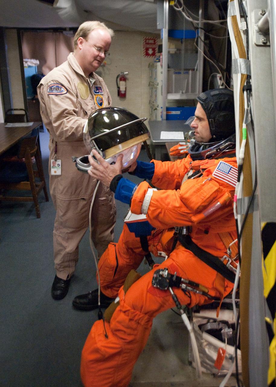 JSC2010-E-124282 (8 Sept. 2010) --- NASA astronaut Greg Chamitoff, STS-134 mission specialist, attired in a training version of his shuttle launch and entry suit, prepares for a training session in the fixed-base shuttle mission simulator (SMS) in the Jake Garn Simulation and Training Facility at NASA?s Johnson Space Center. United Space Alliance suit technician Daniel Palmer assisted Chamitoff. Photo credit: NASA or National Aeronautics and Space Administration
