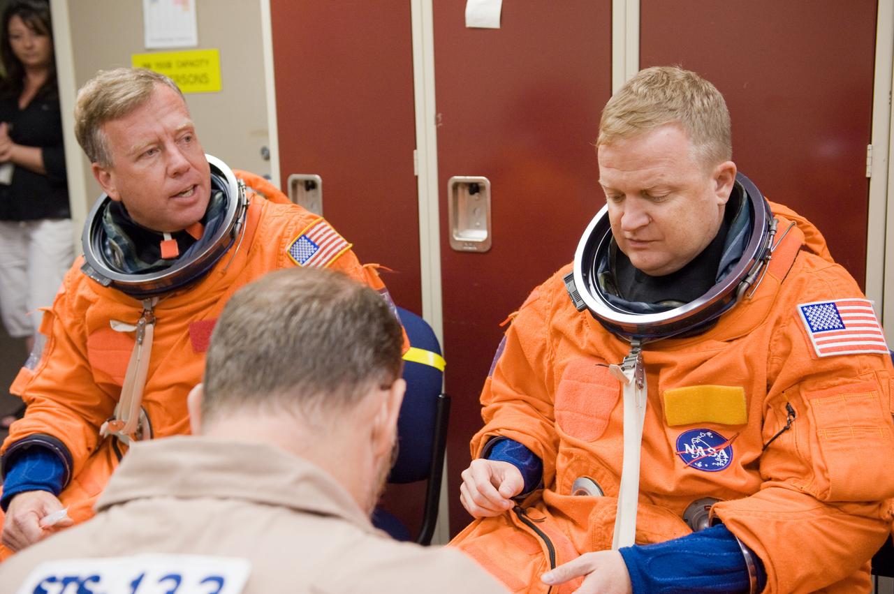 JSC2010-E-166822 (24 Sept. 2010) --- NASA astronauts Steve Lindsey (left), STS-133 commander; and Eric Boe, pilot, don training versions of their shuttle launch and entry suits in preparation for a training session in the Space Vehicle Mock-up Facility at NASA's Johnson Space Center. Photo credit: NASA or National Aeronautics and Space Administration