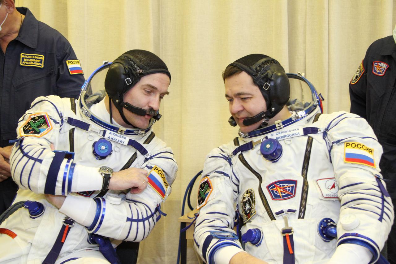 At the Baikonur Cosmodrome in Kazakhstan, Expedition 25 Flight Engineers Alexander Kaleri (L) and Oleg Skripochka share a thought September 26, 2010 as they prepared for a suited checkout of the Soyuz TMA-01M spacecraft they and NASA Flight Engineer Scott Kelly will launch in October 8 to the International Space Station.  Credit: NASA/Victor Zelentsov 