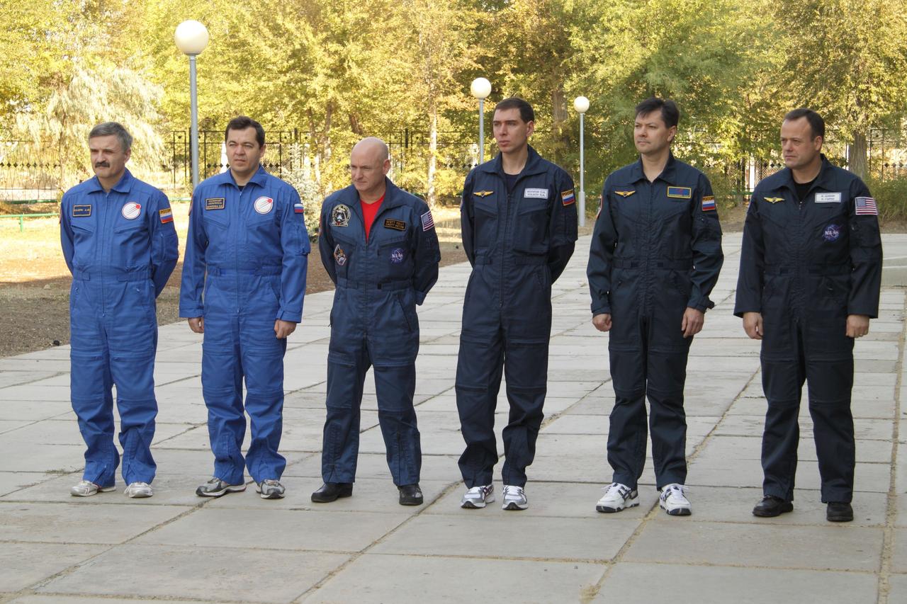 At the Baikonur Cosmodrome in Kazakhstan, the prime and backup crews of Expedition 25 pose for a picture after conducting the traditional raising of flags outside their Cosmonaut Hotel crew quarters September 27, 2010. From left to right are prime crew Flight Engineers Alexander Kaleri, Oleg Skripochka and Scott Kelly, joined by backup crewmembers Sergei Volkov, Oleg Kononenko and Ron Garan. Kelly, Kaleri and Skripochka are completing training for their launch October 8 in the Soyuz TMA-01M spacecraft to the International Space Station.  Credit: NASA/Victor Zelentsov 