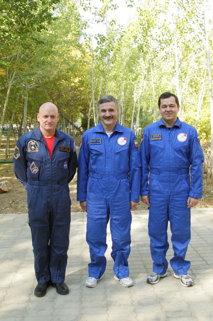 At the Baikonur Cosmodrome in Kazakhstan, the prime crew of Expedition 25 posed for a picture after conducting the traditional raising of flags outside their Cosmonaut Hotel crew quarters September 27, 2010. From left to right are Flight Engineers Scott Kelly of NASA, Alexander Kaleri and Oleg Skripochka. The three crewmembers are completing training for their launch October 8 in the Soyuz TMA-01M spacecraft to the International Space Station.   Credit: NASA/Victor Zelentsov 