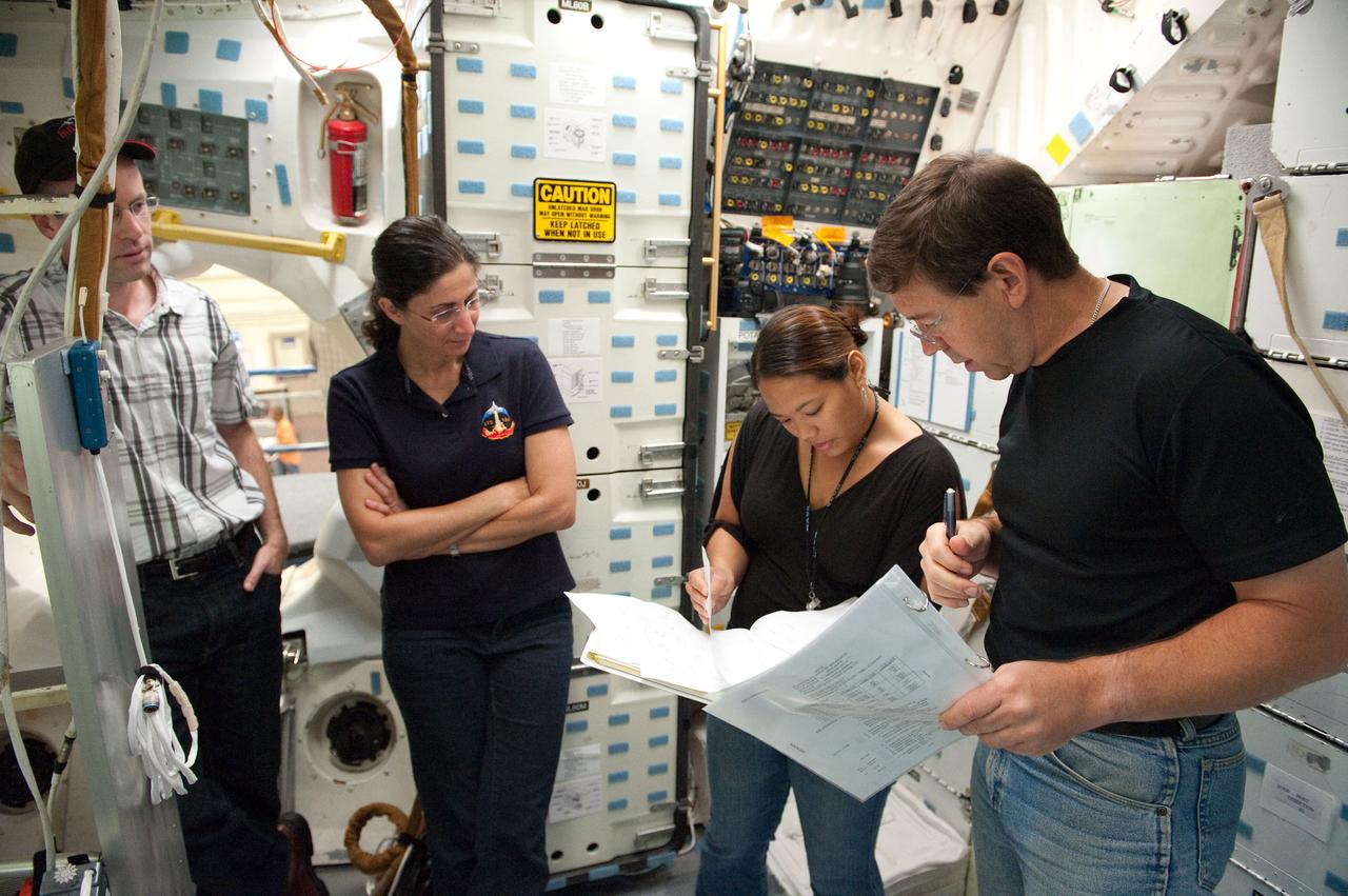JSC2010-E-170396 (29 Sept. 2010) --- NASA astronauts Nicole Stott (second left) and Michael Barratt (right), both STS-133 mission specialists, participate in a training session in an International Space Station mock-up/trainer in the Space Vehicle Mock-up Facility at NASA's Johnson Space Center. Crew instructors Ernest Bell and Jonnie Lynn R. Yaptengco assisted Stott and Barratt. Photo credit: NASA or National Aeronautics and Space Administration