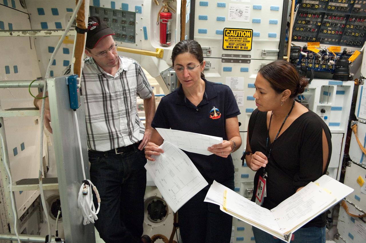 JSC2010-E-170397 (29 Sept. 2010) --- NASA astronaut Nicole Stott (center), STS-133 mission specialist, participates in a training session in an International Space Station mock-up/trainer in the Space Vehicle Mock-up Facility at NASA's Johnson Space Center. Crew instructors Ernest Bell and Jonnie Lynn R. Yaptengco assisted Stott. Photo credit: NASA or National Aeronautics and Space Administration
