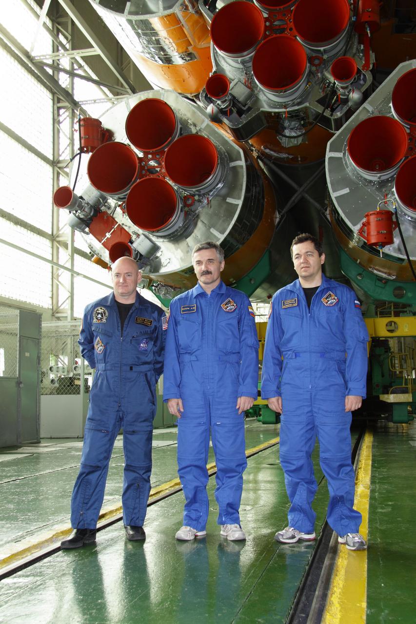 At the Baikonur Cosmodrome in Kazakhstan, Expedition 25 Flight Engineers Scott Kelly of NASA (left), Alexander Kaleri and Oleg Skripochka pose for pictures in front of their Soyuz TMA-01M spacecraft in the Soyuz assembly facility October 3, 2010 as they prepare for launch October 8 en route to the International Space Station.  Credit: NASA/Victor Zelentsov 