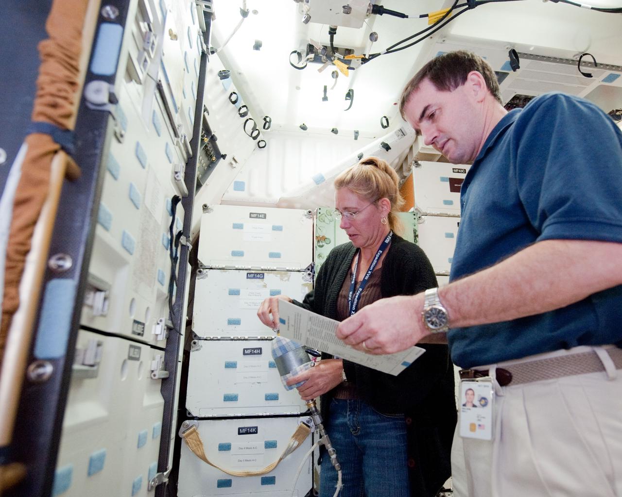 JSC2010-E-170902 (1 Oct. 2010) --- NASA astronaut Sandy Magnus and Rex Walheim, both STS-135 mission specialists, participate in a training session on the middeck of the crew compartment trainer (CCT-2) in the Space Vehicle Mock-up Facility at NASA's Johnson Space Center. STS-135 is planned to be the final mission of the space shuttle program. Photo credit: NASA or National Aeronautics and Space Administration