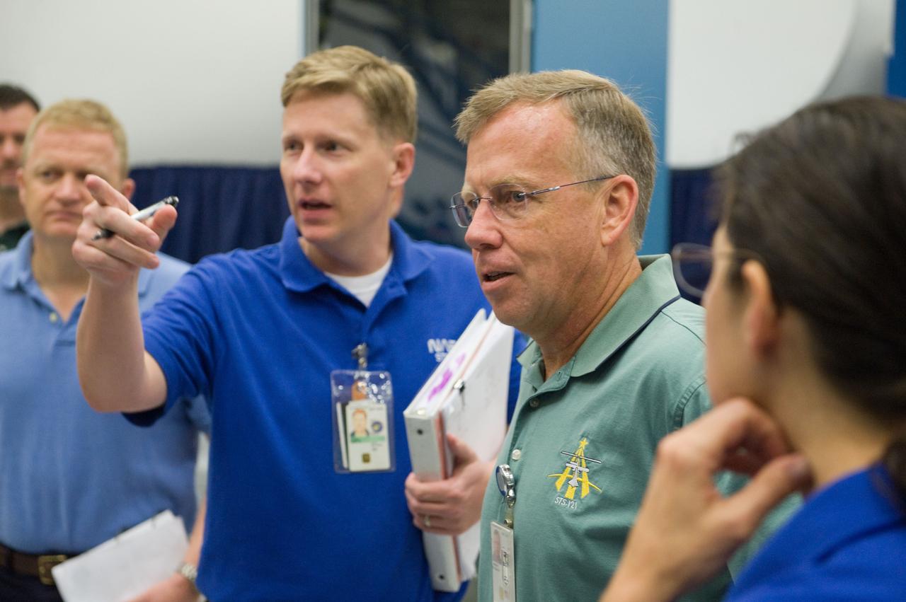 JSC2010-E-171241 (30 Sept. 2010) --- NASA astronauts Steve Lindsey (right), STS-133 commander; Eric Boe (left background), pilot; and Nicole Stott, mission specialist, participate in an ingress/egress timeline training session in the Space Vehicle Mock-up Facility at NASA's Johnson Space Center. Crew instructor Gary W. Kilgo assisted the crew members. Photo credit: NASA or National Aeronautics and Space Administration