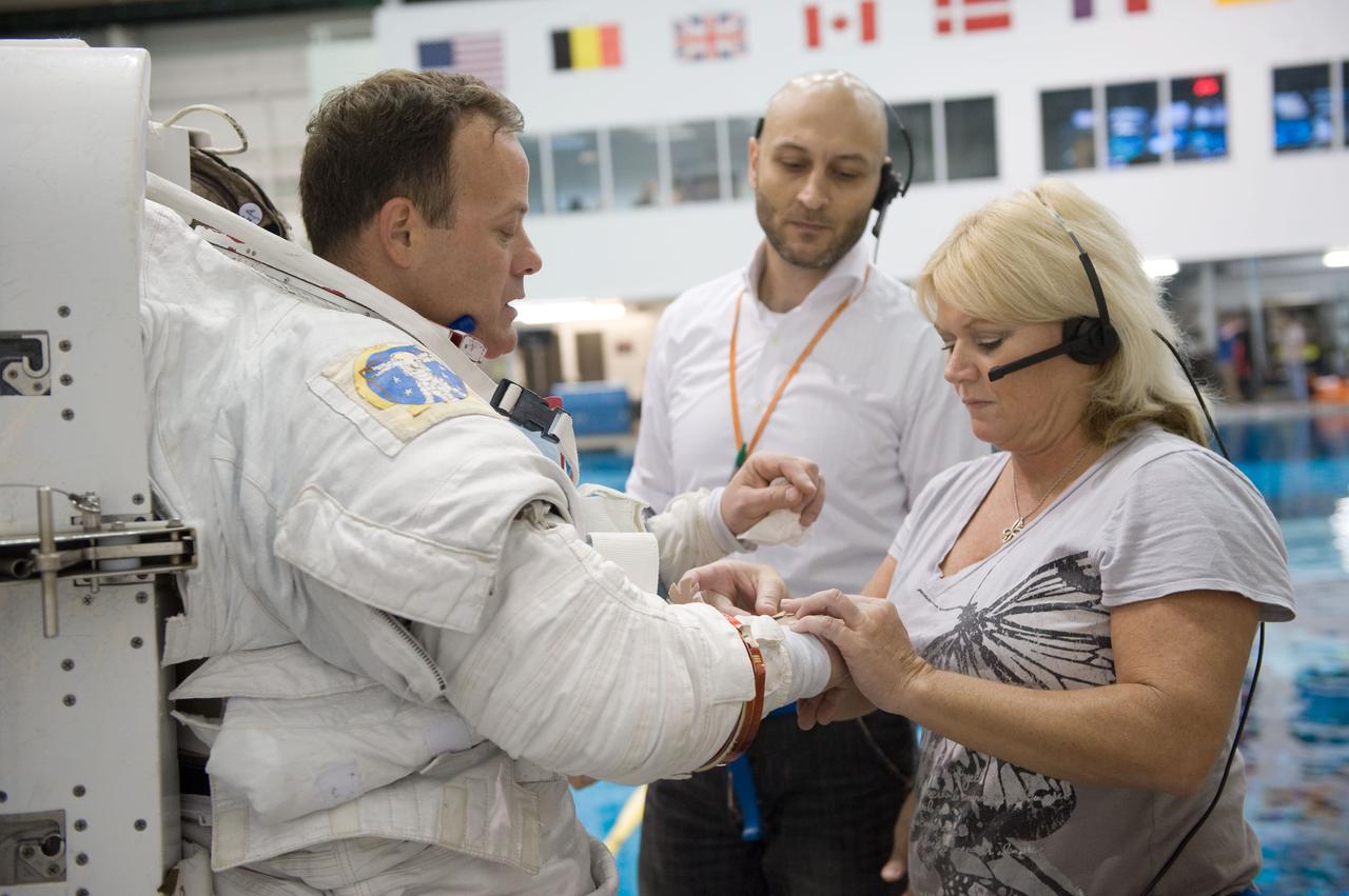 PHOTO DATE: 10-26-10 LOCATION: NBL - Pool Topside SUBJECT: Expedition 27 crew member Ron Garan and Expedition 28 crew member Mike Fossum during a joint INC-27/INC-28 ISS EVA Cleanup training session at the NBL WORK ORDER: 03126-BS__NBLEXP27_10-26-10 PHOTOGRAPHER: BILL STAFFORD
