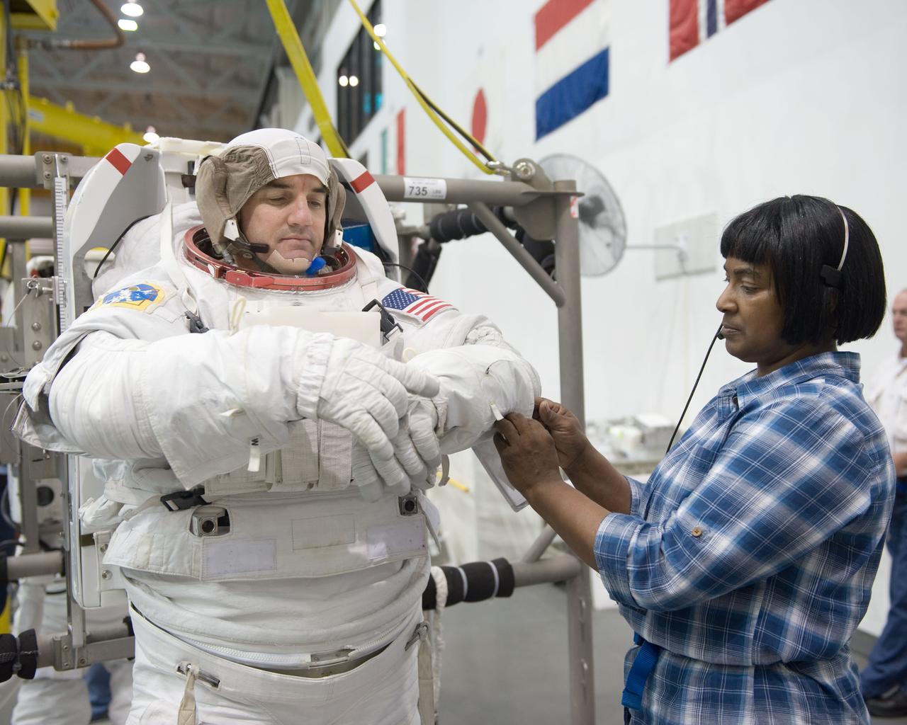 JSC2010-E-181447 (27 Oct. 2010) --- NASA astronaut Rex Walheim, STS-135 mission specialist, gets help donning a training version of his Extravehicular Mobility Unit (EMU) spacesuit in preparation for a spacewalk training session in the waters of the Neutral Buoyancy Laboratory (NBL) near NASA's Johnson Space Center. STS-135 is planned to be the final mission of the space shuttle program. Photo credit: NASA or National Aeronautics and Space Administration