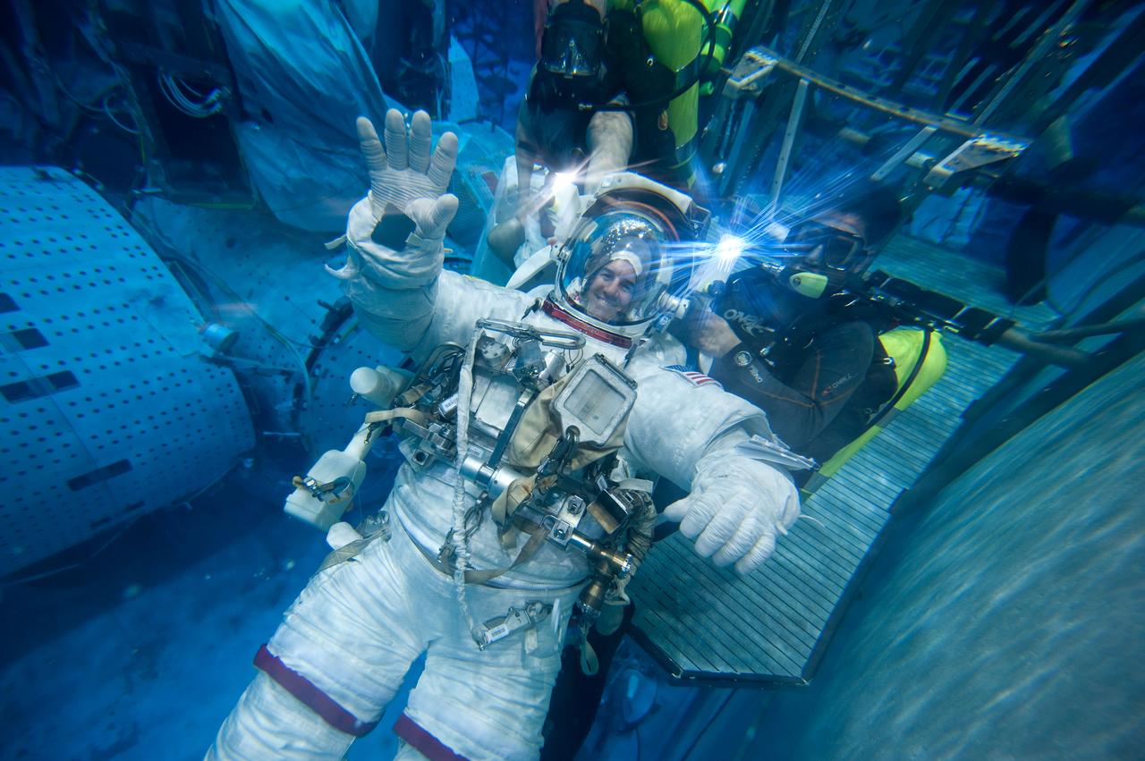 JSC2010-E-181483 (27 Oct. 2010) --- Attired in a training version of his Extravehicular Mobility Unit (EMU) spacesuit, NASA astronaut Rex Walheim, STS-135 mission specialist, participates in a spacewalk training session in the waters of the Neutral Buoyancy Laboratory (NBL) near NASA's Johnson Space Center. Divers are in the water to assist Walheim in his rehearsal, which is intended to help prepare him for work on the exterior of the International Space Station. STS-135 is planned to be the final mission of the space shuttle program. Photo credit: NASA or National Aeronautics and Space Administration