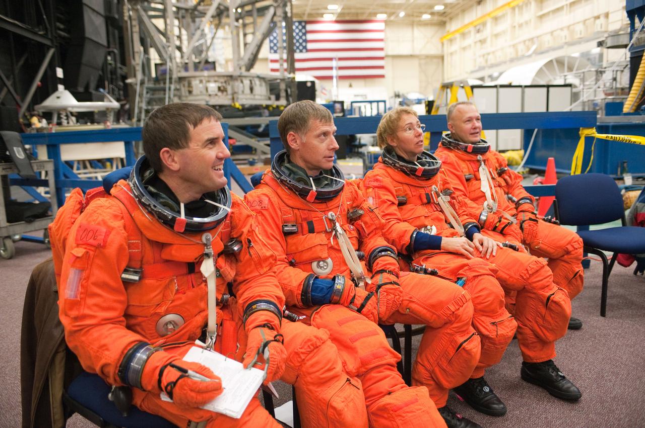 JSC2010-E-183268 (4 Nov. 2010) --- Attired in their training versions of the shuttle launch and entry suit, STS-135 crew members listen to a briefing by a crew trainer prior to the start of a training session in the Space Vehicle Mock-up Facility at NASA's Johnson Space Center. Pictured from the left are NASA astronauts Rex Walheim, mission specialist; Chris Ferguson, commander; Sandy Magnus, mission specialist; and Doug Hurley, pilot. STS-135 is planned to be the final mission of the space shuttle program. Photo credit: NASA or National Aeronautics and Space Administration