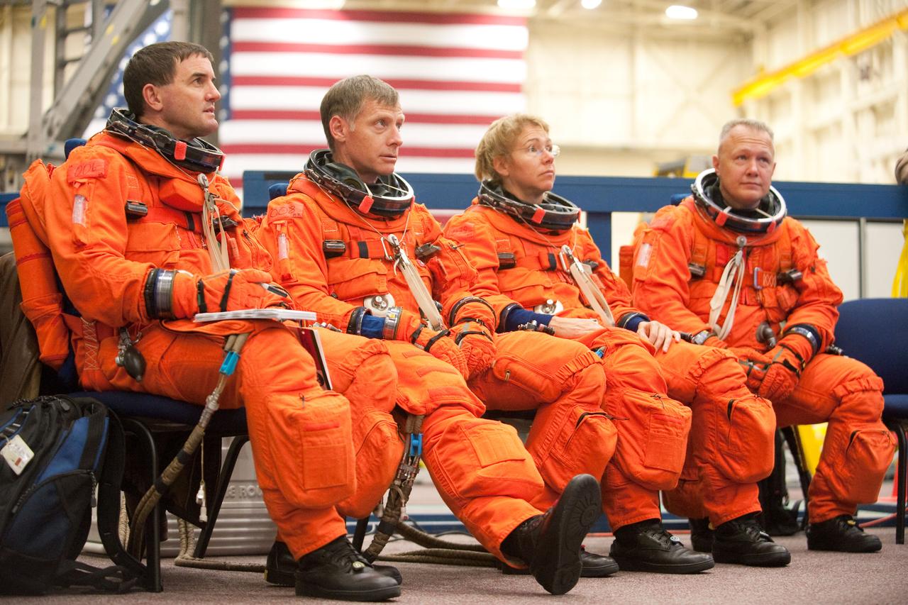 JSC2010-E-183272 (4 Nov. 2010) --- Attired in their training versions of the shuttle launch and entry suit, STS-135 crew members listen to a briefing by a crew trainer prior to the start of a training session in the Space Vehicle Mock-up Facility at NASA's Johnson Space Center. Pictured from the left are NASA astronauts Rex Walheim, mission specialist; Chris Ferguson, commander; Sandy Magnus, mission specialist; and Doug Hurley, pilot. STS-135 is planned to be the final mission of the space shuttle program. Photo credit: NASA or National Aeronautics and Space Administration