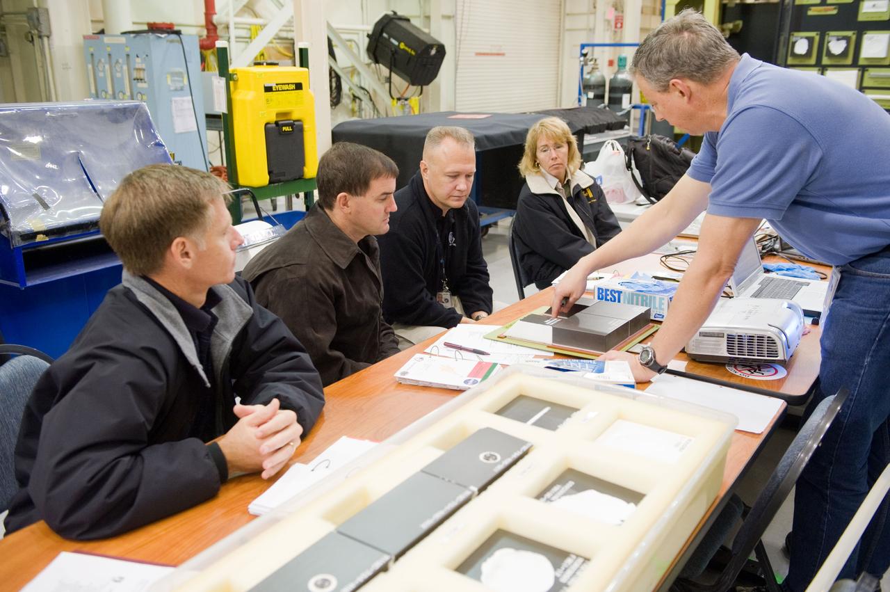 JSC2010-E-183514 (3 Nov. 2010) --- STS-135 crew members participate in an EVA Thermal Protection System (TPS) overview training session in the TPS/ Precision Air Bearing Facility in the Space Vehicle Mock-up Facility at NASA's Johnson Space Center. Pictured from the left are NASA astronauts Chris Ferguson, commander; Rex Walheim, mission specialist; Doug Hurley, pilot; and Sandy Magnus, mission specialist. John Ray (right) assisted the crew members. STS-135 is planned to be the final mission of the space shuttle program. Photo credit: NASA or National Aeronautics and Space Administration