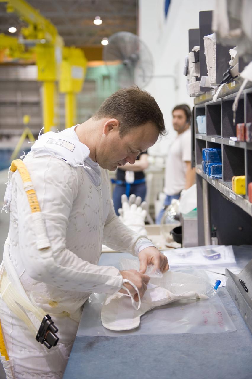 JSC2010-E-187196 (22 Nov. 2010) --- NASA astronaut Ron Garan, Expedition 27/28 flight engineer, works with extravehicular activity (EVA) equipment during a training session in the Neutral Buoyancy Laboratory (NBL) near NASA's Johnson Space Center. Garan is wearing a liquid cooling and ventilation garment that complements his Extravehicular Mobility Unit (EMU) spacesuit. Photo credit: NASA or National Aeronautics and Space Administration
