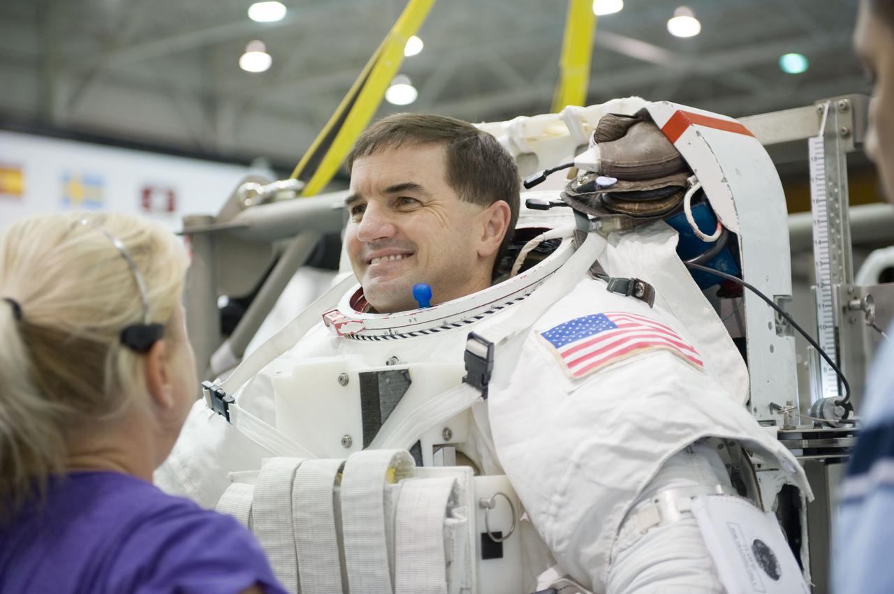 JSC2010-E-187198 (22 Nov. 2010) --- NASA astronaut Rex Walheim, STS-135 mission specialist, gets help donning a training version of his Extravehicular Mobility Unit (EMU) spacesuit in preparation for a spacewalk training session in the waters of the Neutral Buoyancy Laboratory (NBL) near NASA's Johnson Space Center. STS-135 is planned to be the final mission of the space shuttle program. Photo credit: NASA or National Aeronautics and Space Administration