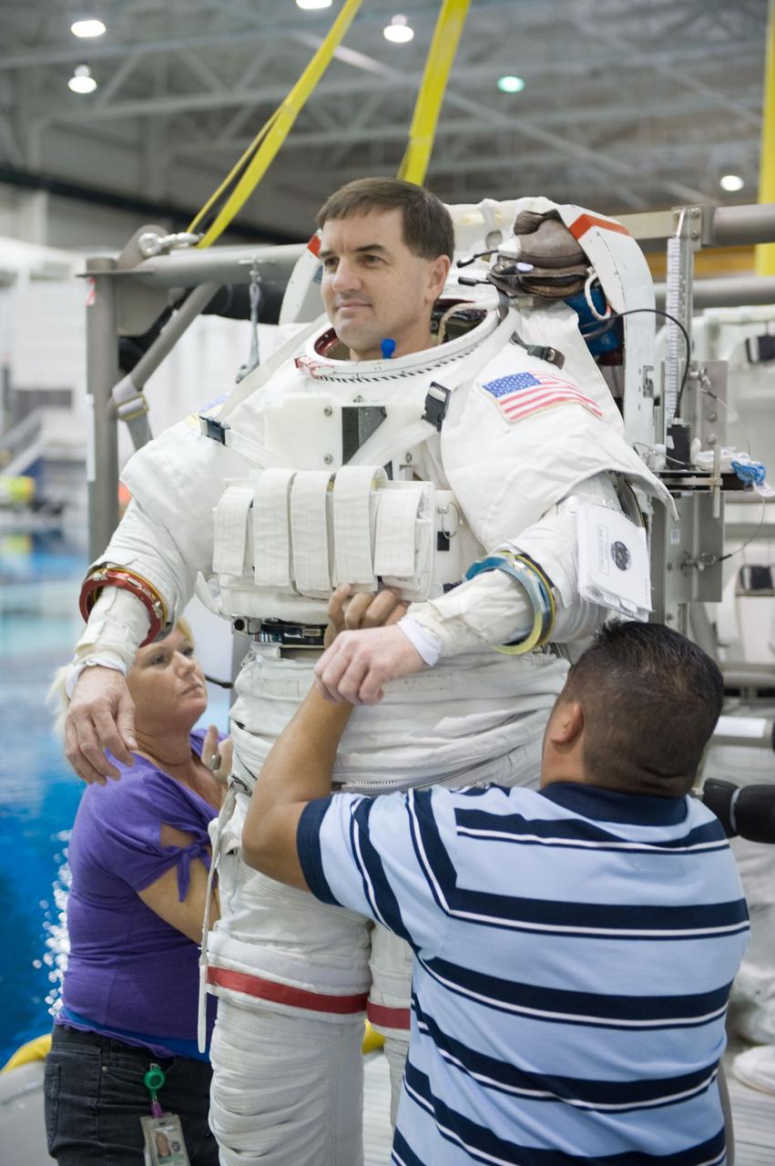 JSC2010-E-187200 (22 Nov. 2010) --- NASA astronaut Rex Walheim, STS-135 mission specialist, gets help donning a training version of his Extravehicular Mobility Unit (EMU) spacesuit in preparation for a spacewalk training session in the waters of the Neutral Buoyancy Laboratory (NBL) near NASA's Johnson Space Center. STS-135 is planned to be the final mission of the space shuttle program. Photo credit: NASA or National Aeronautics and Space Administration