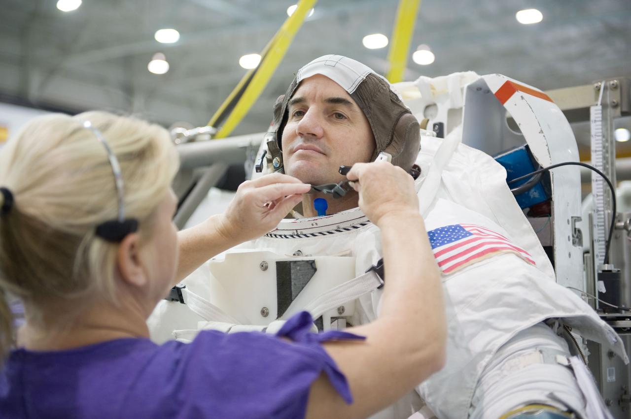 JSC2010-E-187201 (22 Nov. 2010) --- NASA astronaut Rex Walheim, STS-135 mission specialist, gets help donning a training version of his Extravehicular Mobility Unit (EMU) spacesuit in preparation for a spacewalk training session in the waters of the Neutral Buoyancy Laboratory (NBL) near NASA's Johnson Space Center. STS-135 is planned to be the final mission of the space shuttle program. Photo credit: NASA or National Aeronautics and Space Administration