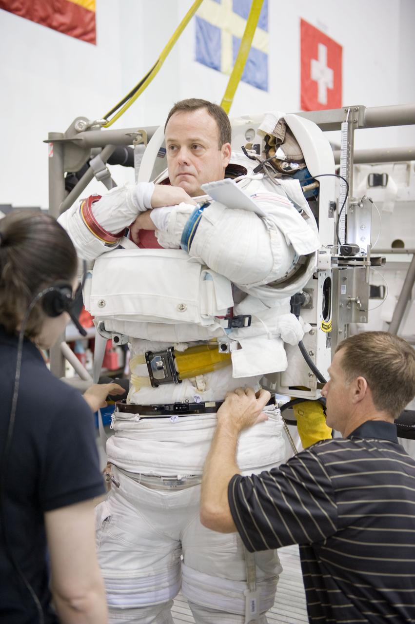 JSC2010-E-187203 (22 Nov. 2010) --- NASA astronaut Ron Garan, Expedition 27/28 flight engineer, dons a training version of his Extravehicular Mobility Unit (EMU) spacesuit in preparation for a spacewalk training session in the waters of the Neutral Buoyancy Laboratory (NBL) near NASA's Johnson Space Center. NASA astronaut Chris Ferguson, STS-135 commander, assisted Garan. Photo credit: NASA or National Aeronautics and Space Administration