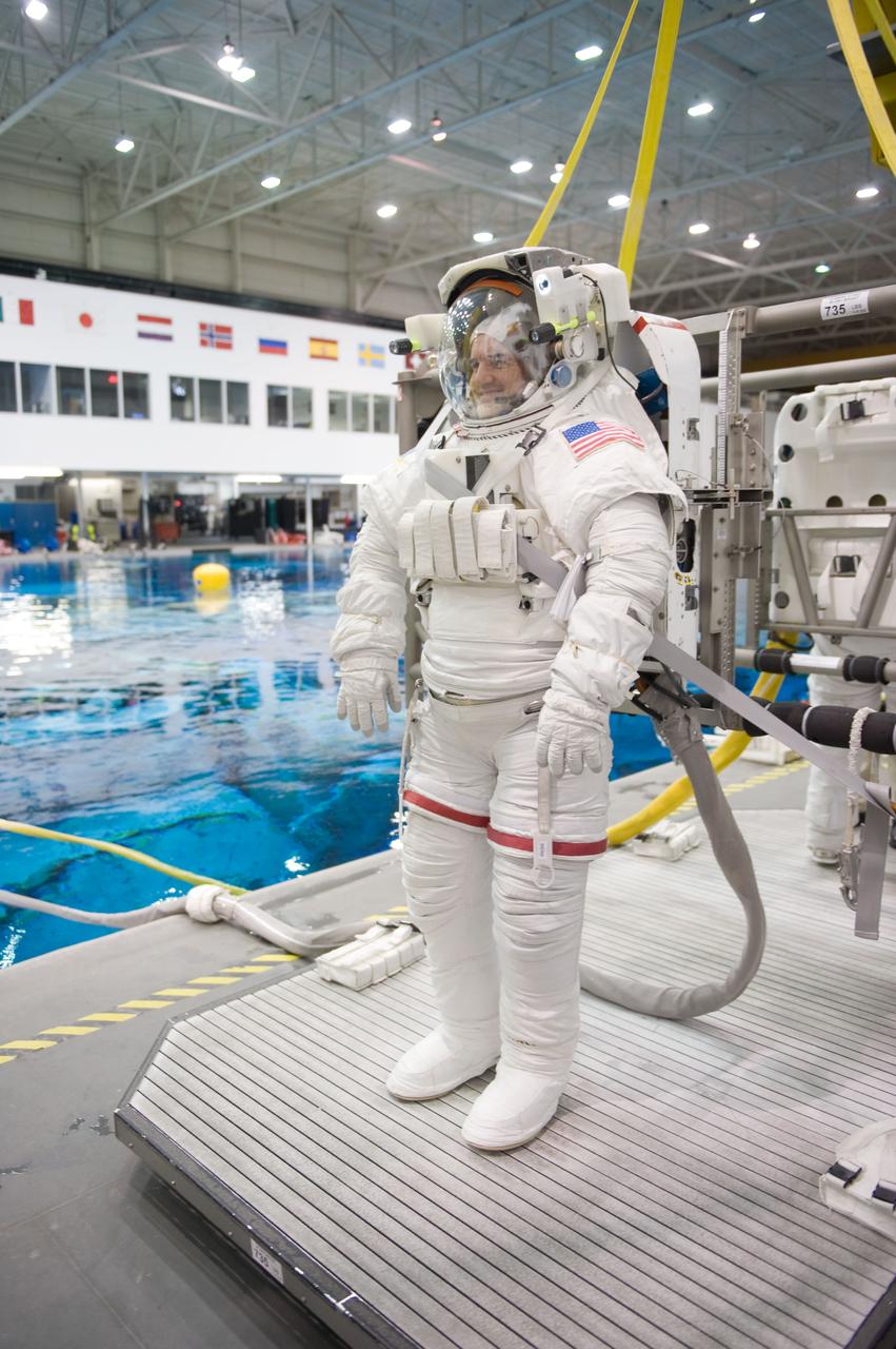 JSC2010-E-187210 (22 Nov. 2010) --- Attired in a training version of his Extravehicular Mobility Unit (EMU) spacesuit, NASA astronaut Rex Walheim, STS-135 mission specialist, is about to be submerged in the waters of the Neutral Buoyancy Laboratory (NBL) near NASA's Johnson Space Center. Divers (out of frame) are in the water to assist Walheim in his rehearsal, which is intended to help prepare him for work on the exterior of the International Space Station. STS-135 is planned to be the final mission of the space shuttle program. Photo credit: NASA or National Aeronautics and Space Administration