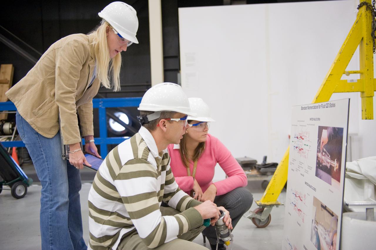JSC2010-E-193913 (1 Dec. 2010) --- NASA astronaut Andrew Feustel, STS-134 mission specialist, participates in an extravehicular activity (EVA) training session in the Partial Gravity Simulator (POGO) test area in the Space Vehicle Mock-up Facility at NASA?s Johnson Space Center. Crew instructors Allison Bolinger (standing) and Vickie Otto assisted Feustel. Photo credit: NASA or National Aeronautics and Space Administration