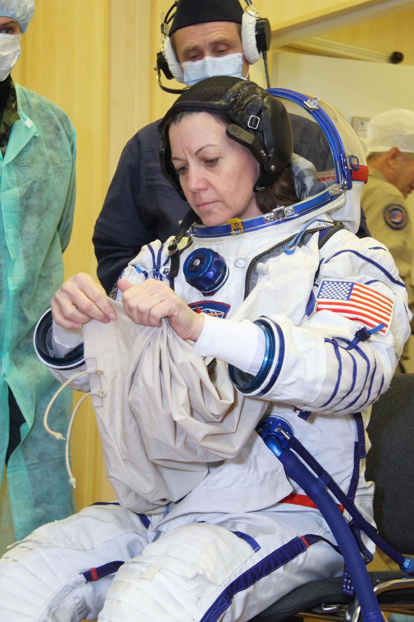 At the Baikonur Cosmodrome in Kazakhstan, Expedition 26 Flight Engineer Catherine Coleman of NASA suits up in her Russian Sokol launch and entry suit for a fit check in the Soyuz TMA-20 spacecraft December 4, 2010. Coleman, European Space Agency Flight Engineer Paolo Nespoli and Soyuz Commander Dmitry Kondratyev will launch December 16 (Baikonur time) to the International Space Station. Credit: NASA/Victor Zelentsov