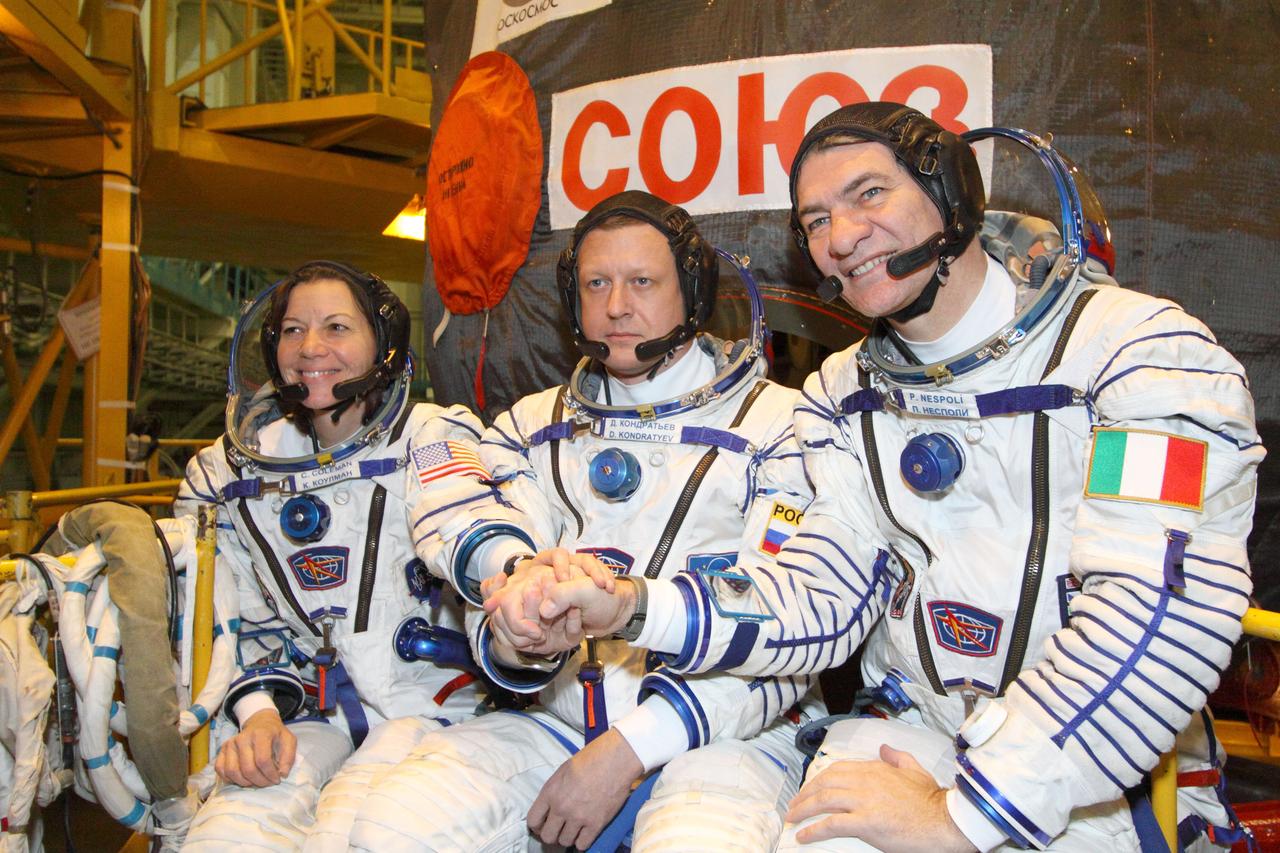 At the Baikonur Cosmodrome in Kazakhstan, Expedition 26 Flight Engineer Catherine Coleman (left), Soyuz Commander Dmitry Kondratyev (center) and Flight Engineer Paolo Nespoli of the European Space Agency (right) pose for pictures December 4, 2010 outside their Soyuz TMA-20 spacecraft during a fit check exercise. The trio will launch in the Soyuz December 16 (Baikonur time) to the International Space Station.  Credit: NASA/Victor Zelentsov 