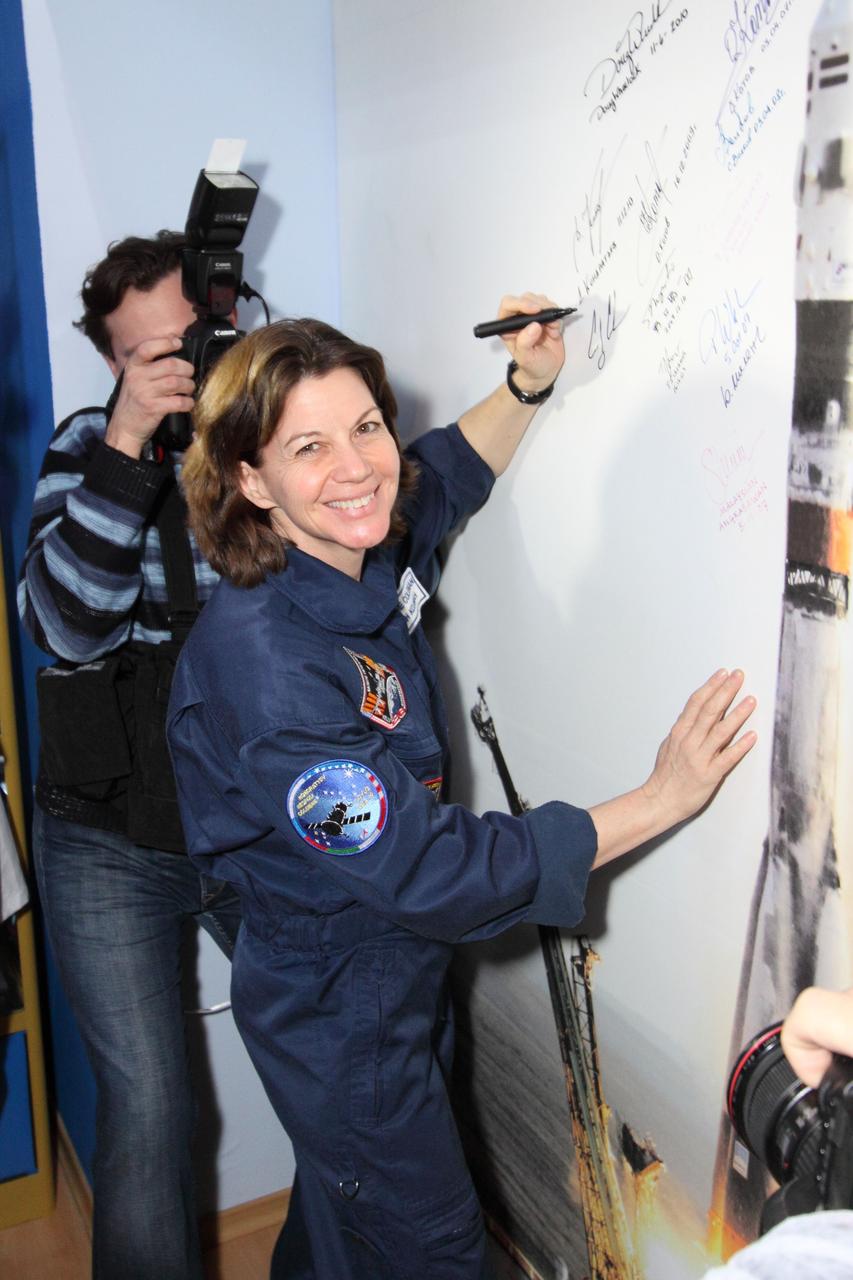 Coleman signs a Soyuz launch picture in the Korolev Museum in the Baikonur Cosmodrome.  -NASA/Victor Zelentsov